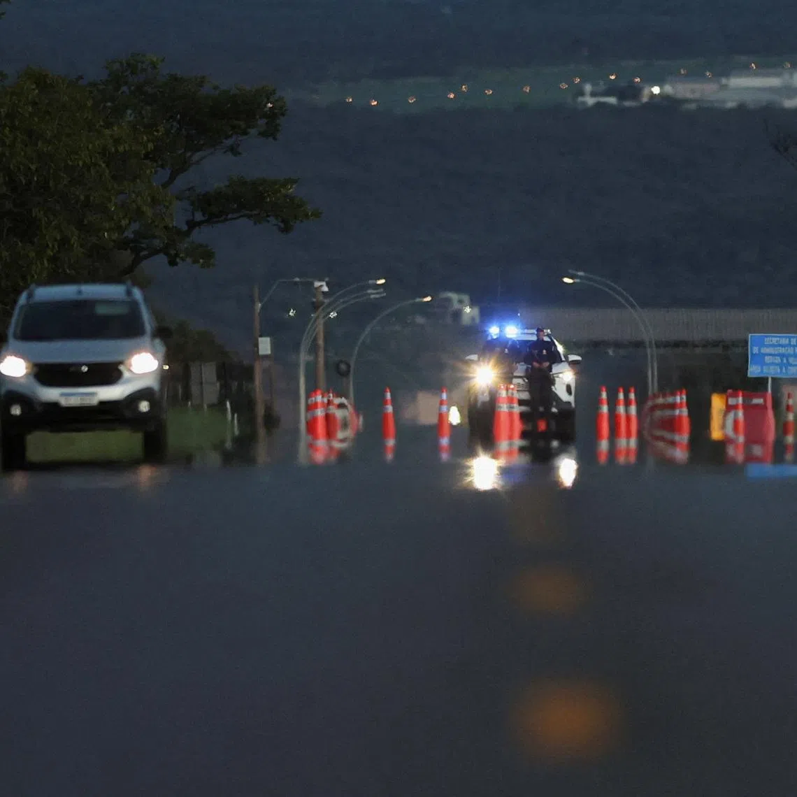 Police officers stand guard on the access road to the Papuda Penitentiary Complex after Supreme Court Justice Alexandre de Moraes ordered the transfer of former President Jair Bolsonaro, who was convicted by a Supreme Court majority of plotting a coup to remain in power after losing the 2022 election, in Brasilia, Brazil, January 15, 2026. REUTERS/Adriano Machado