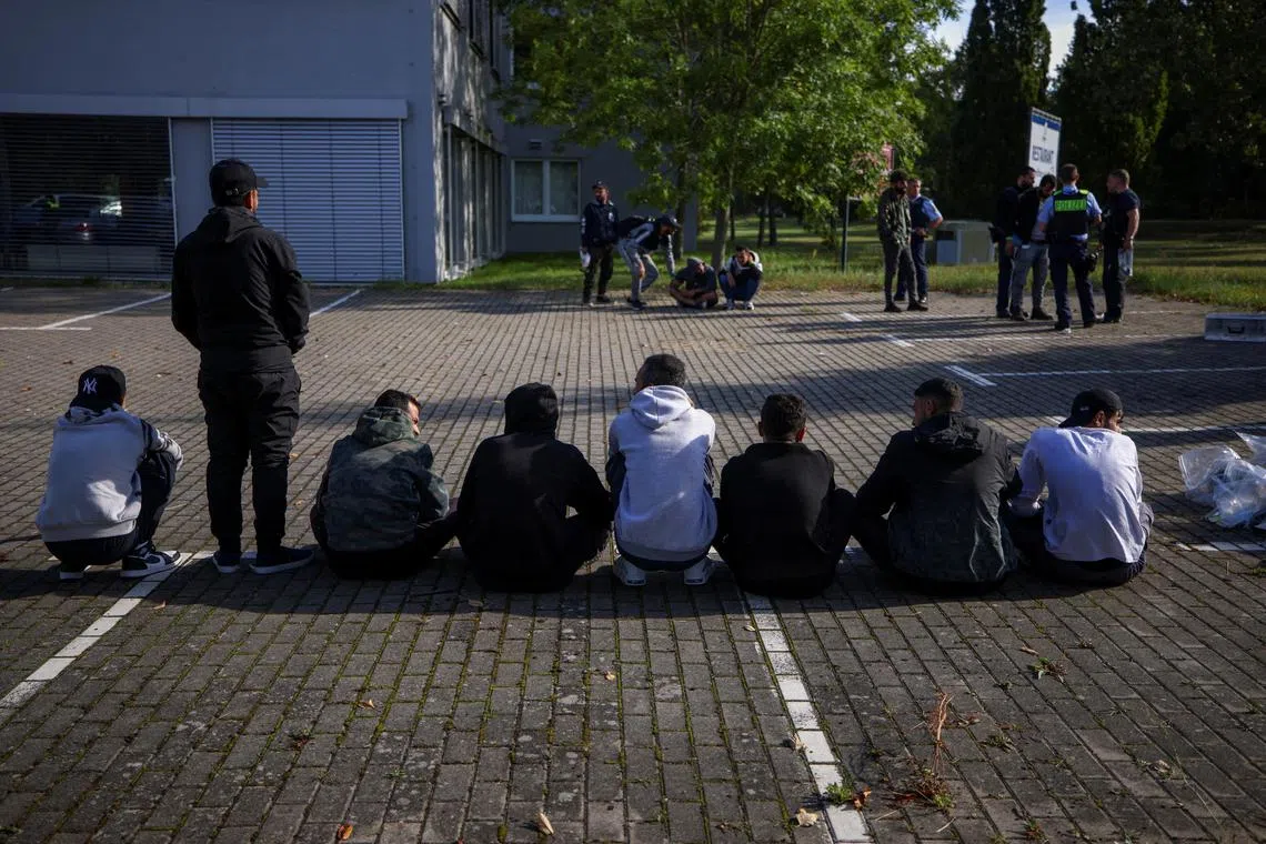 FILE PHOTO: Suspected illegal migrants sit on the ground after they were detained by German police during their patrol along the German-Polish border to prevent illegal migration, in Forst, Germany, September 20, 2023. REUTERS/Lisi Niesner/File Photo