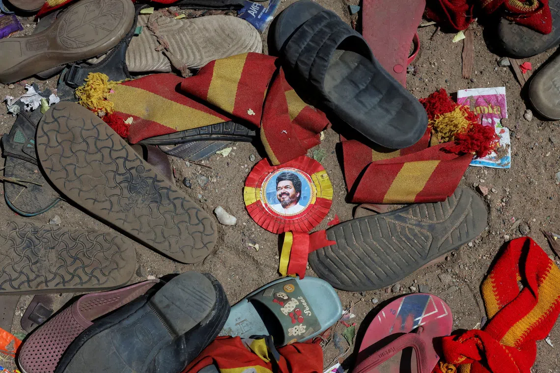 A badge with picture of Vijay, actor and politician, lies amid footwears and other belongings left by attendees at the site of a stampede incident during an election campaign rally held by Tamilaga Vettri Kazhagam party, in Karur district of Tamil Nadu, India, September 28, 2025. REUTERS/Priyanshu Singh     TPX IMAGES OF THE DAY