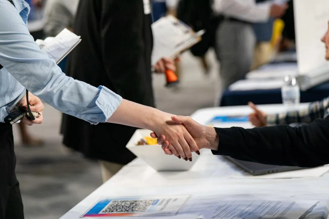 A recruiter and a job seeker shake hands at the Appalachian State University internship and job fair in Boone, North Carolina, US, on Wednesday, Oct. 1, 2025. The Department of Labor is expected to release initial jobless claims figures on October 2. Photographer: Allison Joyce/Bloomberg