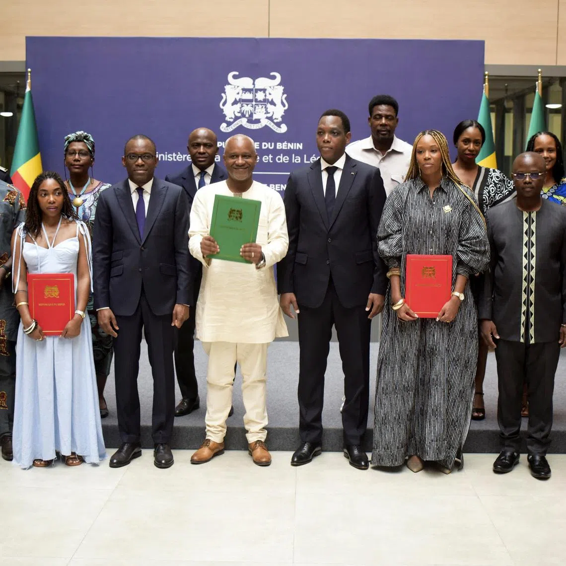 Isaline Attely (3rd from R), an Afro-descendant from Martinique, and other Afro-descendants, who obtained their Beninese nationality, pose for a photograph with Benin's Foreign Minister Olushegun Adjadi Bakari and other Beninese officials, during a naturalisation ceremony in Cotonou, Benin, December 27, 2025. REUTERS/Charles Tossou Placide