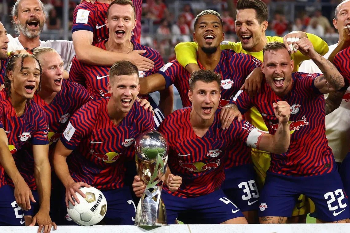 RB Leipzig's Xavi Simons, Willi Orban, Benjamin Henrichs, Dani Olmo and David Raum pose with the trophy after winning the German Super Cup.