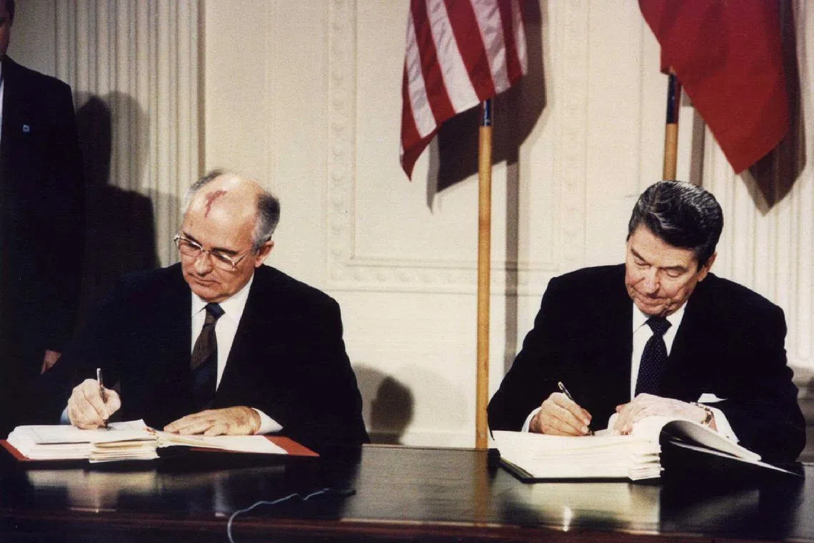 FILE PHOTO: File photo of U.S. President Ronald Reagan (R) and Soviet President Mikhail Gorbachev signing the Intermediate-Range Nuclear Forces (INF) treaty at the White House, on December 8 1987. REUTERS/Dennis Paquin//File Photo
