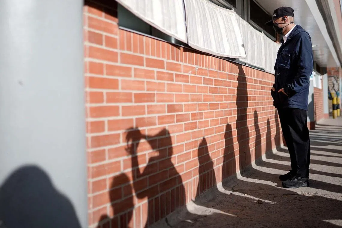A person checking ID lists outside a polling station in a runoff vote between right-wing presidential candidate Abelardo De La Espriella and leftist candidate Ivan Cepeda, in Bogota, Colombia, on June 21.