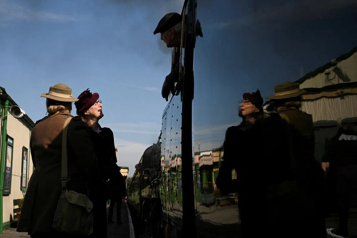 Women dressed in 1940's attire greeting the locomotive driver of the Canadian Pacific, an iconic steam locomotive built in 1941, as it returns to service, at Alton Station in Alton, Hampshire, Britain, on March 19 2025. 