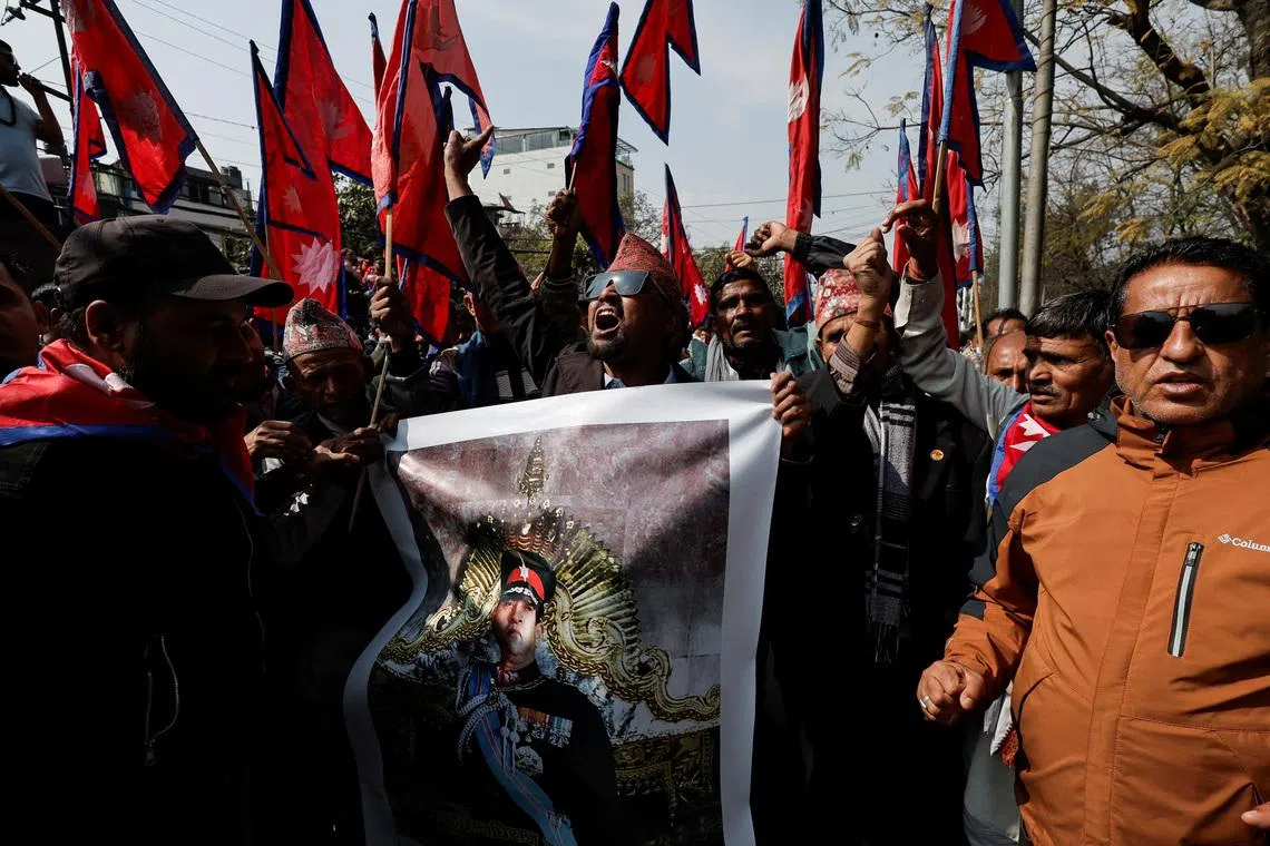 Pro-monarchy supporters holding a portrait of former King of Nepal Gyanendra Bir Bikram Shah Dev, chant slogans as they wait to welcome him in Kathmandu, Nepal, February 13, 2026. REUTERS/Navesh Chitrakar