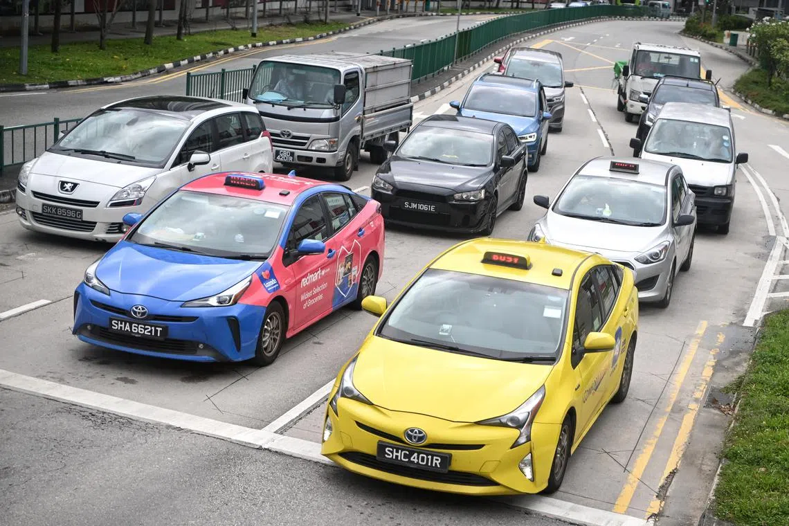 ComfortDelGro taxis (blue and yellow) and a Silvercab taxi of the Premier Taxis operator seen at a traffic junction along Circuit Link on Feb 20, 2023.