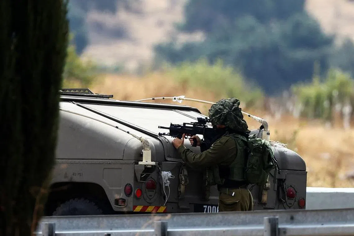 An Israeli soldier looks through the site of his gun, as tension mounts between the Lebanon and Israel, in northern Israel, October 10, 2023. REUTERS/Lisi Niesner