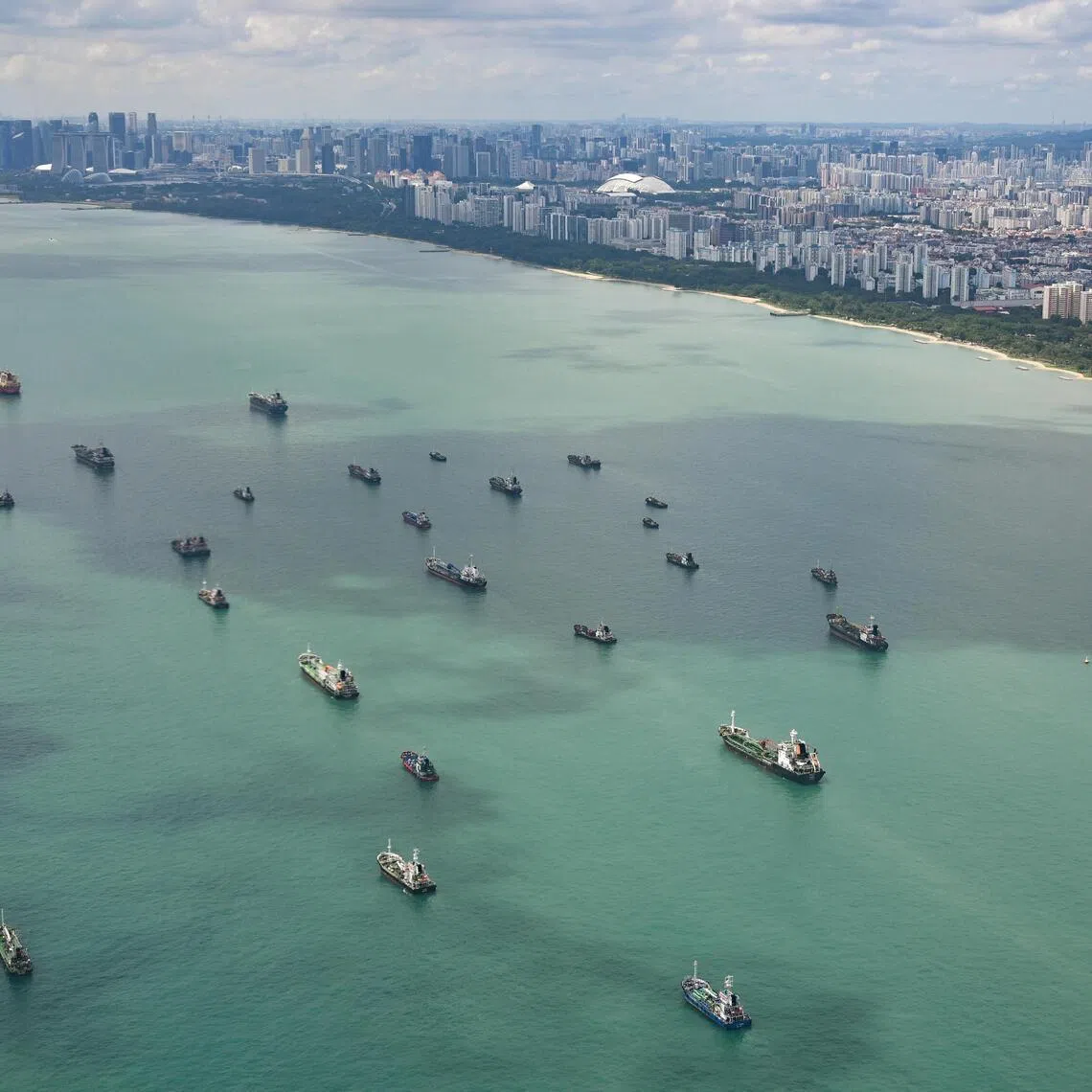 Some 350 global commodity traders have a significant presence in Singapore.
Ships anchored off Marina Bay and East Coast Park as seen during flight on plane on Dec 1, 2024. Three tracts of land could be reclaimed off East Coast Park in the coming decades, creating about 800ha of land for new homes and other amenities, as well as a new reservoir. Called the Long Island, these land tracts are Singapore's response to the threat of rising sea levels and inland flooding in the East Coast area. Can be used for stories on budget, money, oil, goods, business, shipping, cargo, reclamation, supply, trade, and vessel.