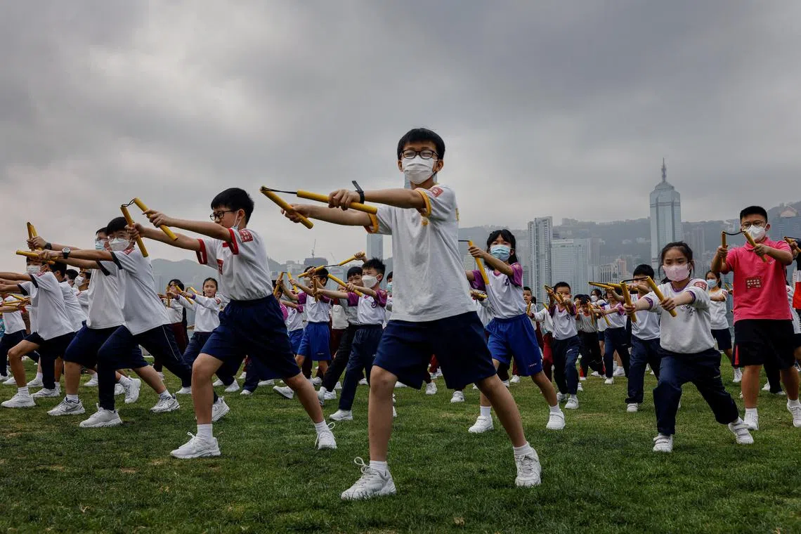 FILE PHOTO: Heung Yee Kuk Yuen Long District Secondary School students attend a nunchaku performance event by the sea, in a tribute to the late martial artist and actor Bruce Lee, ahead of National Security Education Day, in Hong Kong, China April 14, 2023.  REUTERS/Tyrone Siu/File Photo