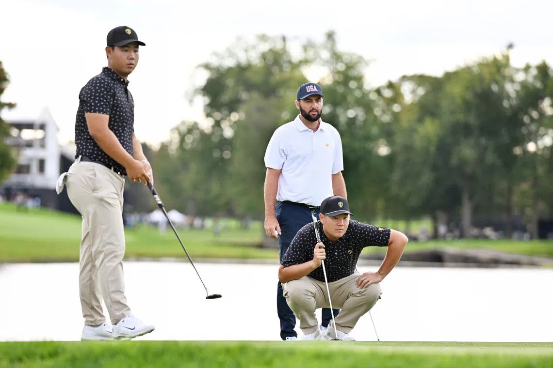 Im Sung-jae of the International Team lining up a putt on the 15th green as teammate Tom Kim and Scottie Scheffler of the US Team look on during the four-ball matches at the 2024 Presidents Cup.