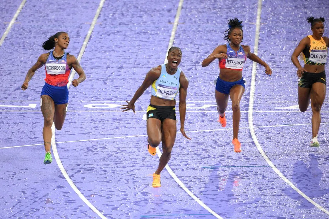 Julien Alfred celebrates after crossing the line to win gold ahead of silver medallist Sha'Carri Richardson of United States. 