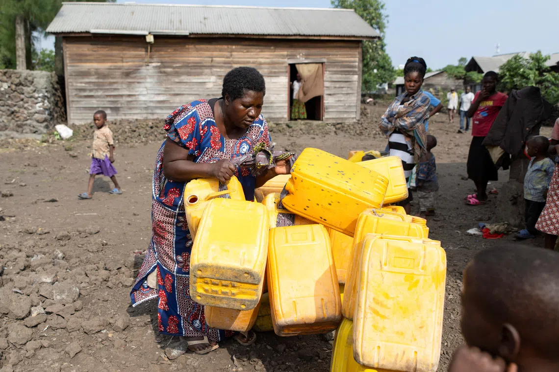 A woman arranges jerrycans as people queue at the standpipe, where incomplete water connections caused by USAID funding cuts to the NGO Mercy Corps have led to ongoing water shortages, in Goma, North Kivu province, Democratic Republic of Congo, June 16, 2025. REUTERS/Arlette Bashizi