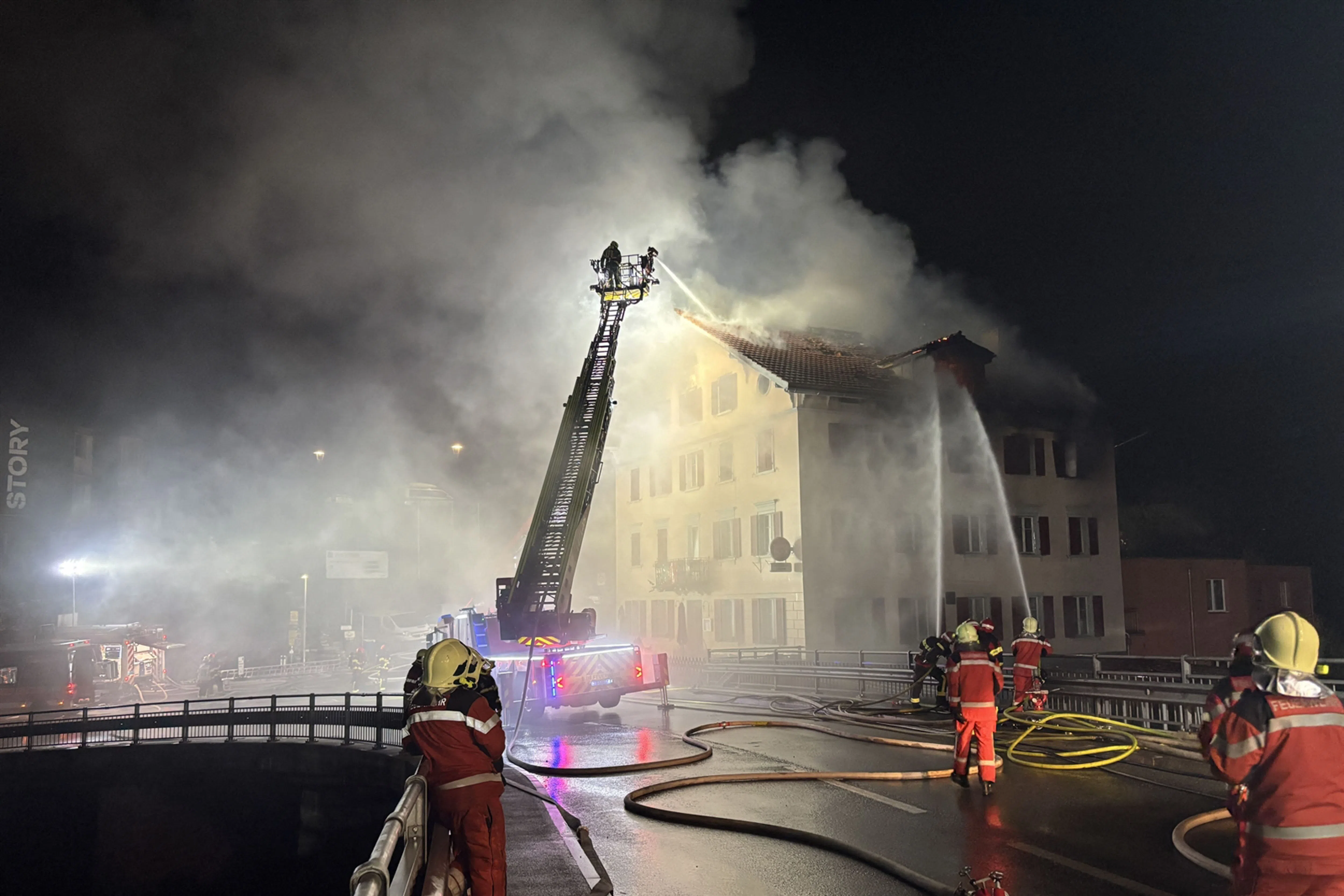 TOPSHOT - This handout photograph taken and released on August 21, 2026 by the Cantonal Police of Graubunden (Kantonspolizei Graubunden) shows a firefighters working to extinguish a fire that broke out in a building in the small town of Thusis, eastern Switzerland. A fire that broke out overnight on August 21, 2026, in a building in the small town of Thusis, in eastern Switzerland, left eight people injured and five missing, according to local police, who were alerted shortly after midnight. (Photo by Handout / Kantonspolizei Graubünden / AFP) / RESTRICTED TO EDITORIAL USE - MANDATORY CREDIT "AFP PHOTO /  Cantonal Police of Grison (Kantonspolizei Graubunden)/ HANDOUT /" - HANDOUT - NO MARKETING NO ADVERTISING CAMPAIGNS - DISTRIBUTED AS A SERVICE TO CLIENTS