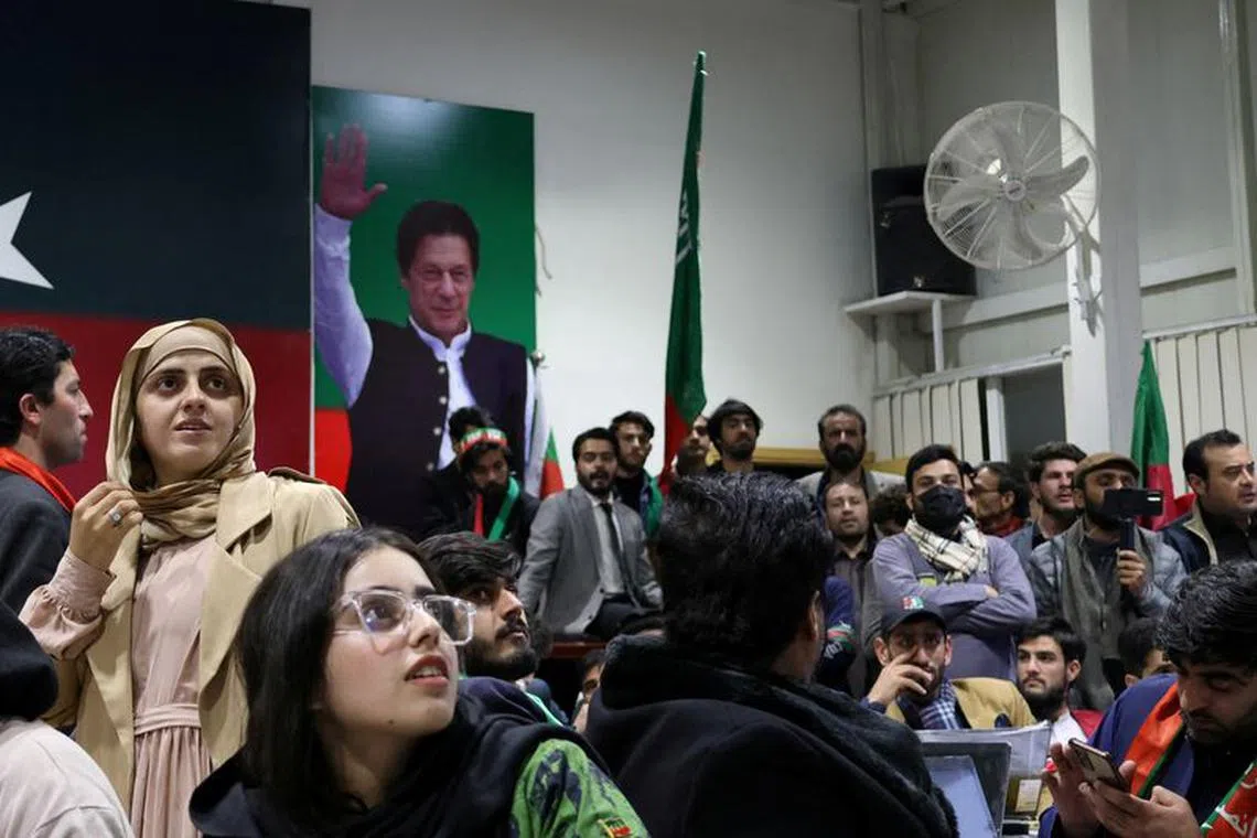 FILE PHOTO: Volunteers for former Prime Minister Imran Khan's party Pakistan Tehreek-e-Insaf (PTI) look on as they watch results on TV screens in Islamabad, Pakistan, February 8, 2024. REUTERS/Charlotte Greenfield/File Photo