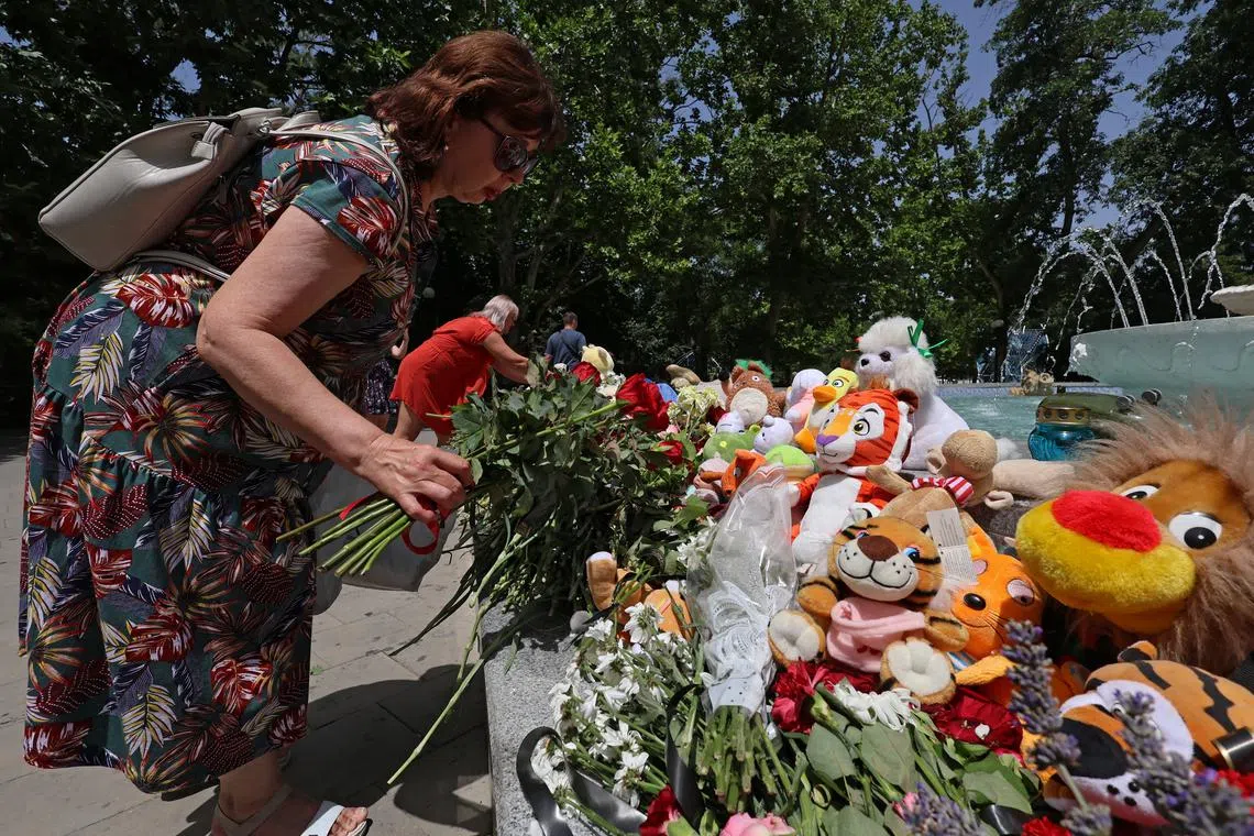 A woman lays flowers at a makeshift memorial to victims of a shelling, in Sevastopol, Crimea.