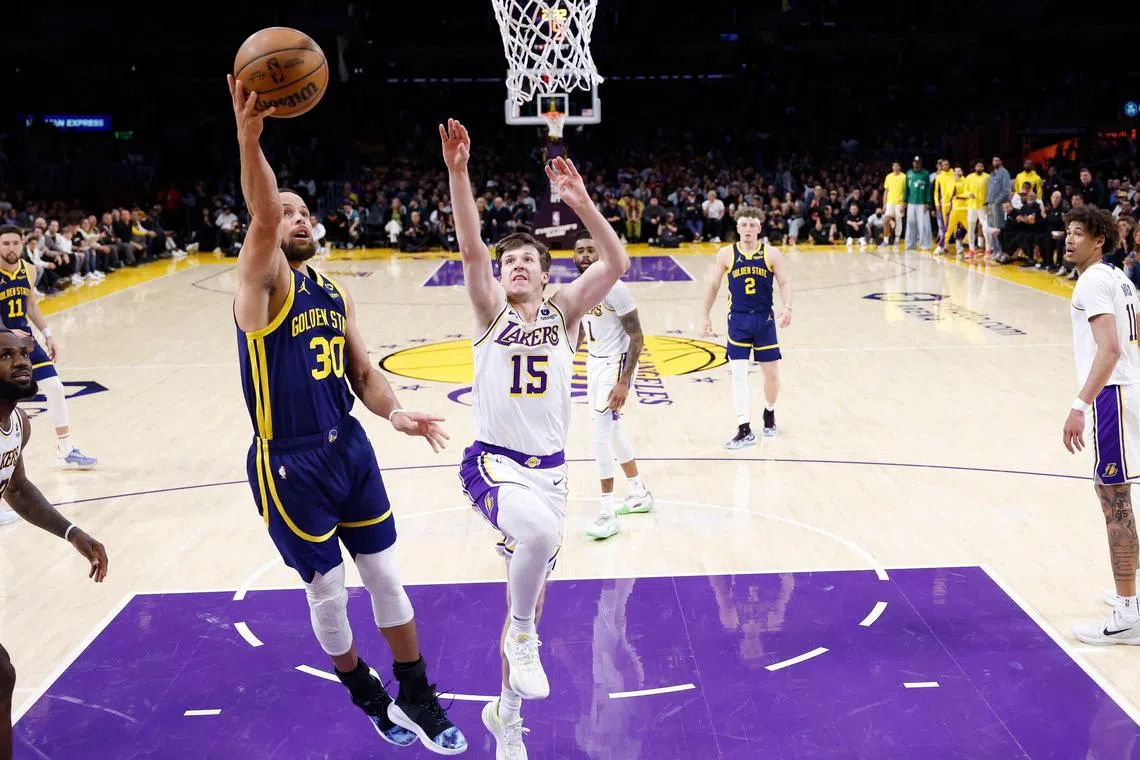 Stephen Curry of the Golden State Warriors shoots past the defence of Austin Reaves of the Los Angeles Lakers during the second half at Crypto.com Arena.