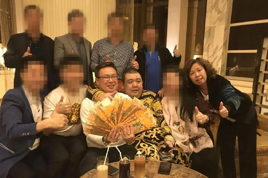 Singaporean couple Wan Hoe Keet (seated, left) and his wife Sally Ho with scheme founder Peter Ong in a 2018 meeting in Macau.
