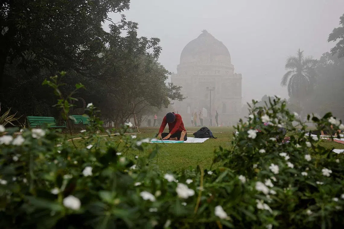 A man practicing yoga in Lodhi Garden while the sky is enveloped with smog after Delhi's air quality turned "hazardous" due to alarming air pollution, in New Delhi, India, Nov 15, 2024. 