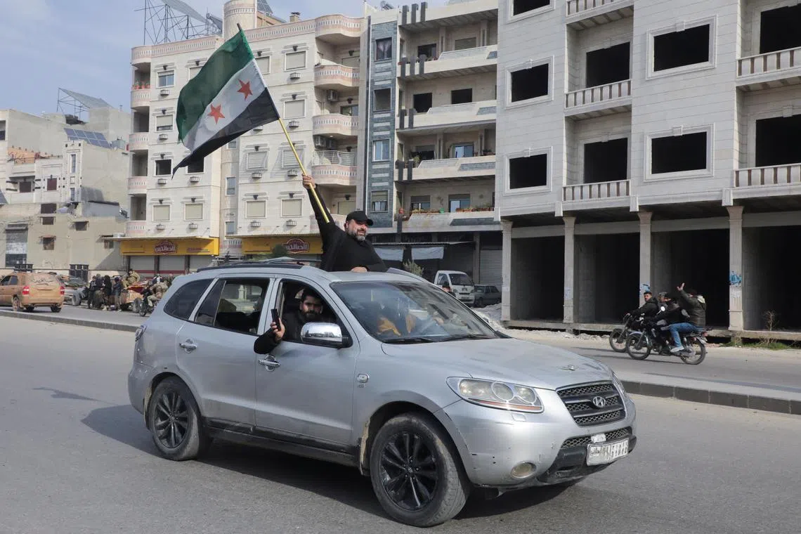 A person holding a Syrian opposition flag in Hama, Syria, on Dec 6.