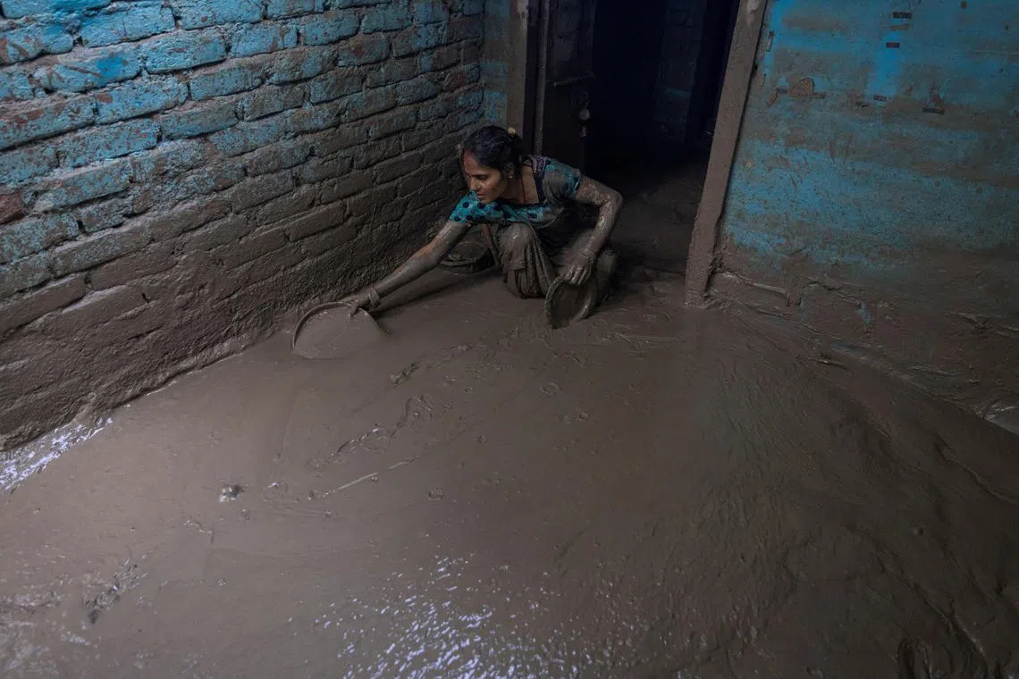 Munni Devi, 28, cleans the mud from the entrance of her house as flood water recedes from a residential area that was flooded by the overflowing of the river Yamuna following heavy rains, in New Delhi, India, July 17, 2023. REUTERS/Adnan Abidi     TPX IMAGES OF THE DAY     