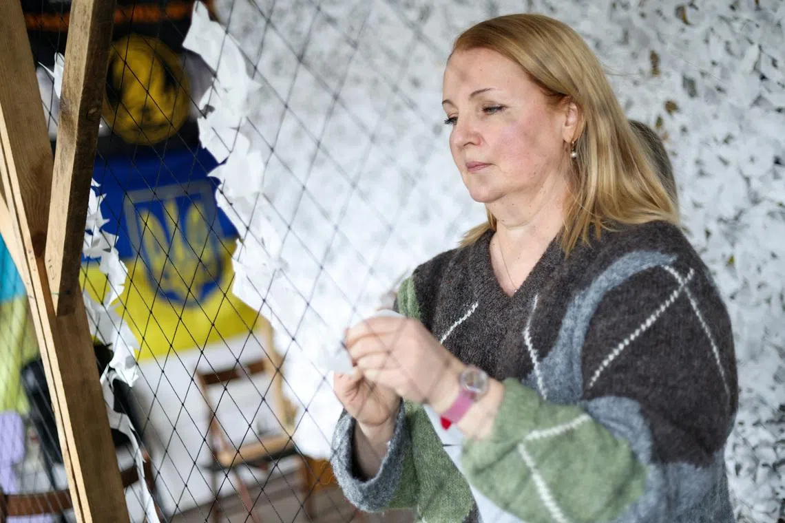 Maryna Bondarenko, a Ukrainian who has been living with her son in Poland for 4 years, weaves a camouflage net for Ukrainian soldiers at UA HUB, a Ukrainian social and cultural centre, in Warsaw, Poland, February 15, 2026. REUTERS/Kuba Stezycki
