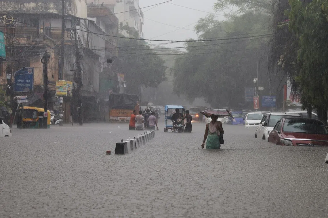 People wading through a flooded street after heavy rains in New Delhi, India, on July 8.