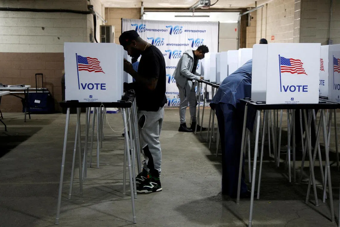 Voters fill out their ballots for the presidential election during early voting at the Detroit Elections Office on Oct 28.