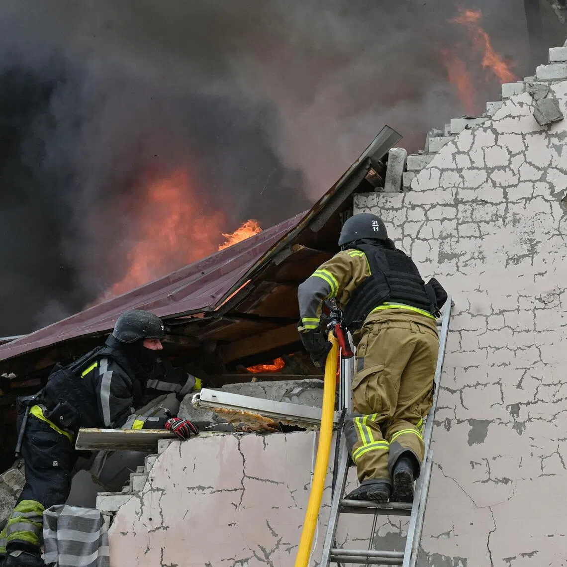 Ukrainian firefighters working at the scene of a Russian air strike on a car repair workshop in Kharkiv on Oct 5.