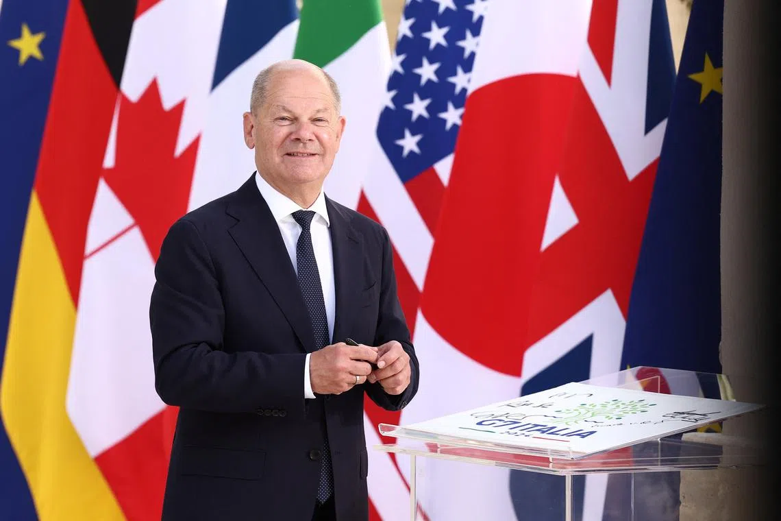 German Chancellor Olaf Scholz signs a paper, on the first day of the G7 summit, at the Borgo Egnazia resort, in Savelletri, Italy June 13, 2024. REUTERS/Guglielmo Mangiapane