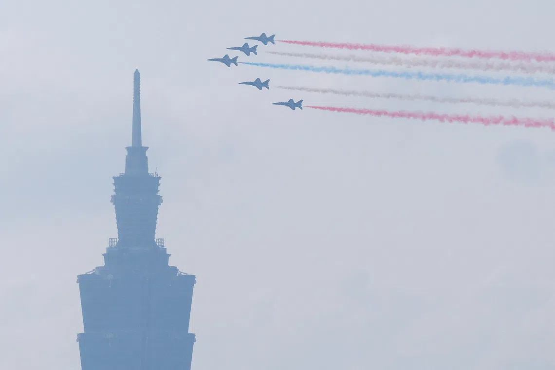 AT-3 advanced jet trainers releasing coloured trails as they fly in formation past Taipei 101, during a Taiwan's National Day rehearsal in Taipei, Taiwan, on Oct 8, 2025. 