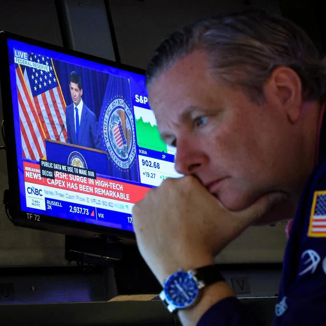 A trader working on July 29 at the New York Stock Exchange, as a broadcast of US Federal Reserve chairman Kevin Warsh plays in the background.
