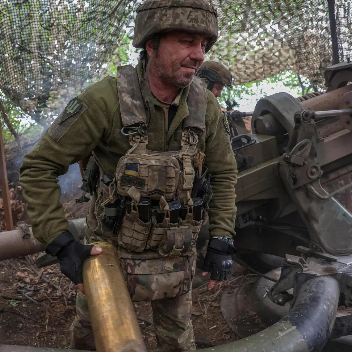 Ukrainian servicemen fire a howitzer towards Russian troops, in Ukraine's Donetsk region.