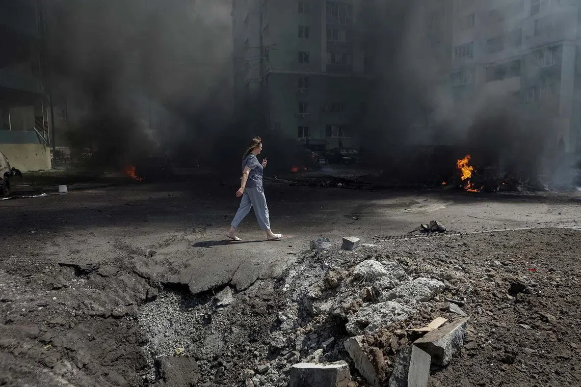 A woman walking at the site of a Russian air strike, amid Russia's attack on Ukraine, in Kharkiv, Ukraine, July 24, 2025. 