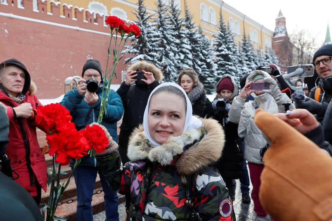 Maria Andreeva, whose husband was mobilised in October 2022 to join the Russian armed forces involved in a military campaign in Ukraine, lays flowers at the Tomb of the Unknown Soldier by the Kremlin wall in Moscow, Russia, January 20, 2024. Andreeva is an active member of Russian women's movement \"Way Home\", demanding the return from the frontline of their husbands, sons and brothers. REUTERS/Stringer