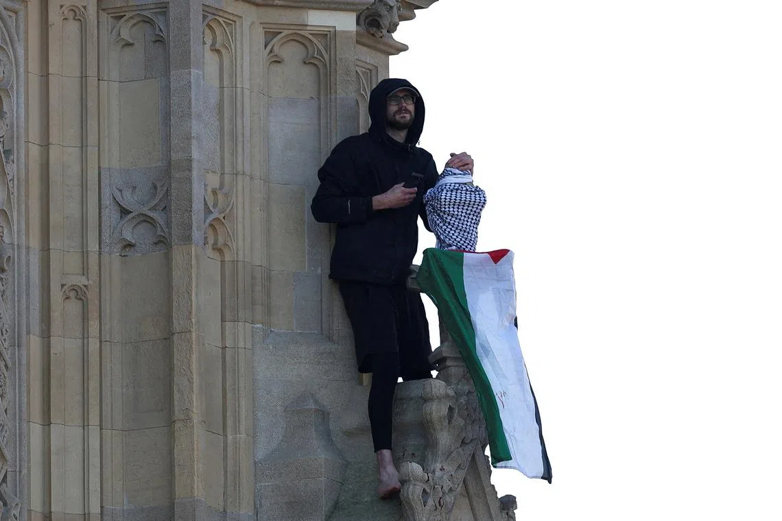 A man holding a Palestinian flag climbs the Elizabeth Tower, commonly known as Big Ben, next to Houses of Parliament, in London, Britain March 8, 2025. REUTERS/Hannah McKay