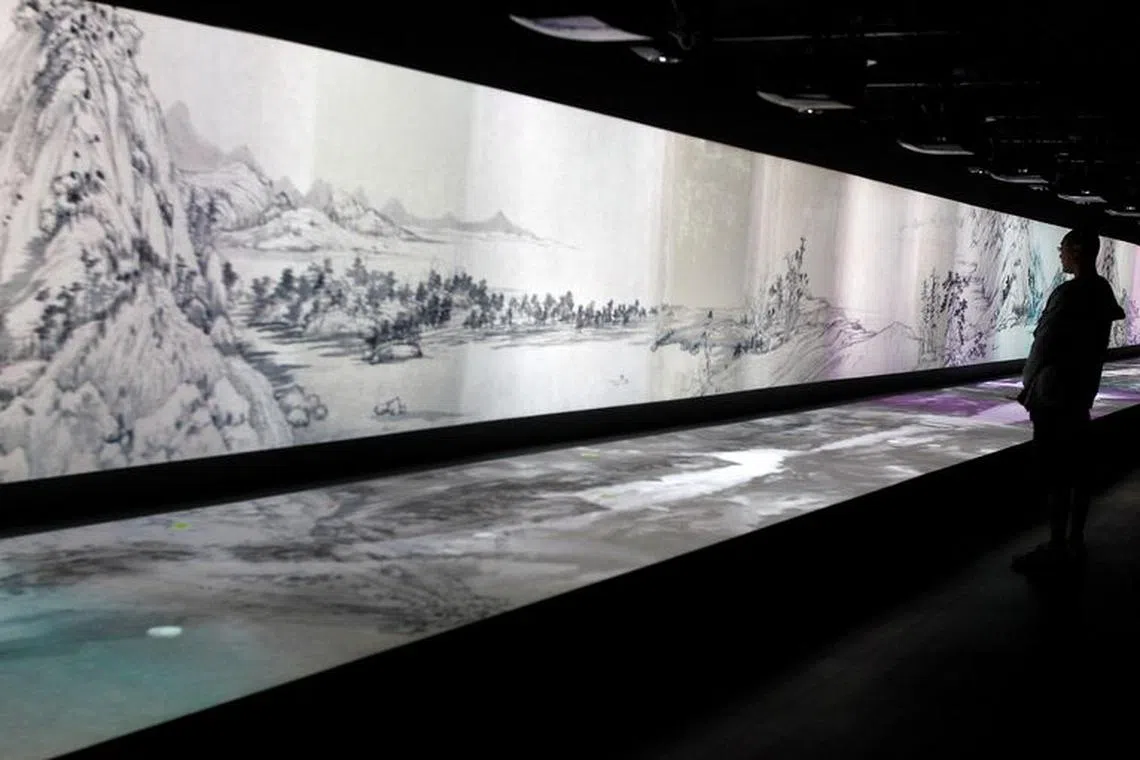 FILE PHOTO: A visitor looks at an audio/visual interpretation of a painting entitled &#039;Dwelling in the Fuchun Mountains&#039; by Chinese painter Huang Gongwang at the National Palace Museum in Taipei, June 1, 2011.  REUTERS/Pichi Chuang/File Photo