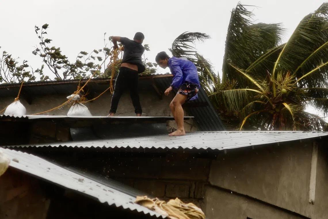 Villagers reinforce a house in the coastal town of Aparri, Cagayan province, Philippines, on 7 Nov.