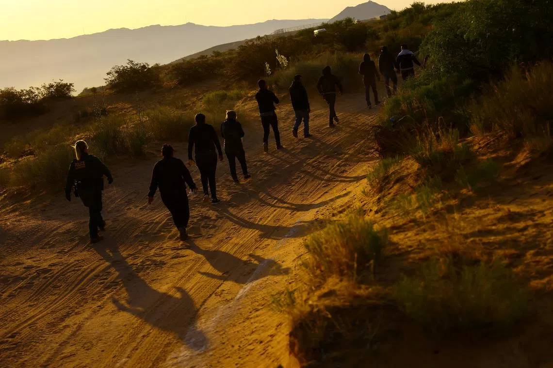 FILE PHOTO: U.S. Border Patrol agents detain migrants who attempted to cross the U.S.-Mexico border undetected, in an area outside Sunland Park desert, New Mexico, U.S., June 23 2023. REUTERS/Jose Luis Gonzalez/File Photo