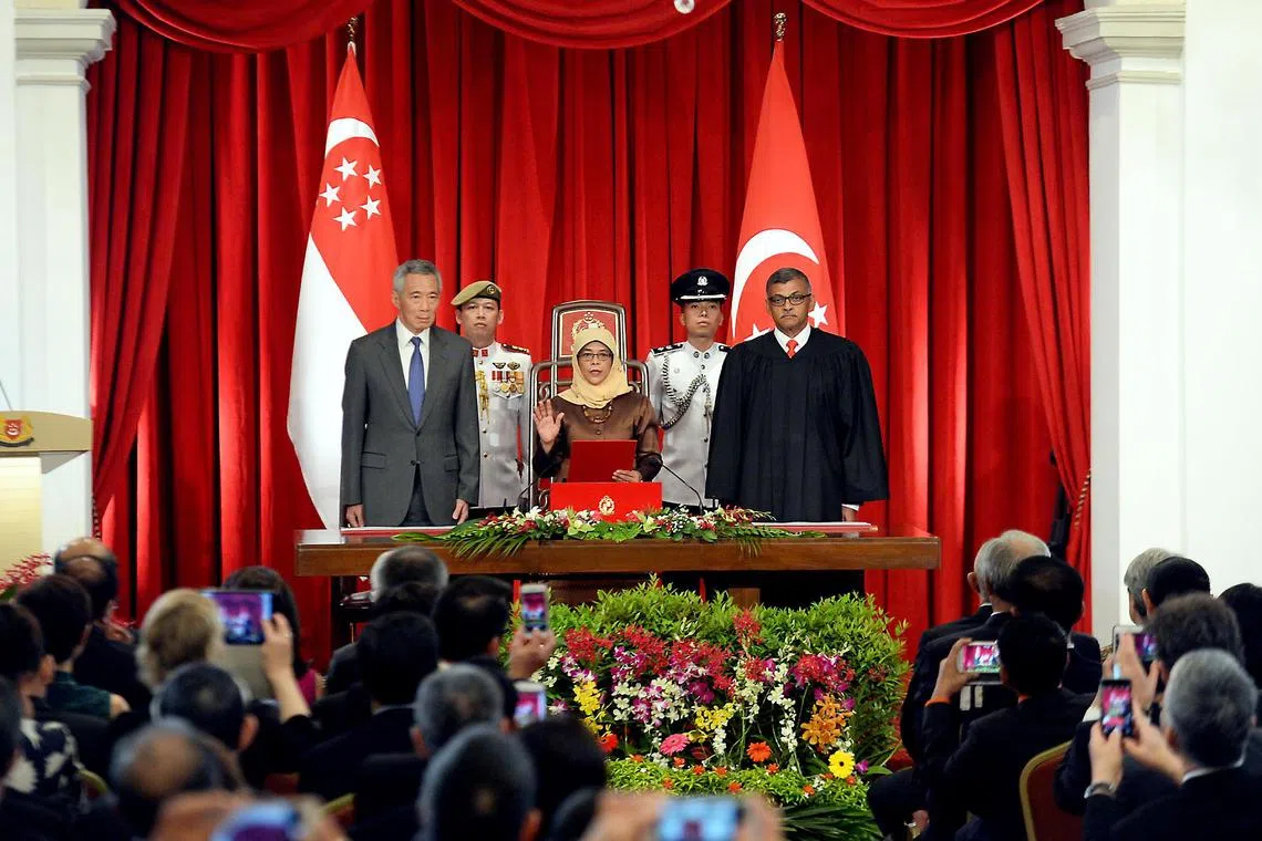 Madam Halimah Yacob, flanked by Prime Minister Lee Hsien Loong and Chief Justice Sundaresh Menon, being sworn in as Singapore’s eighth President at the Istana on Sept 14, 2017.