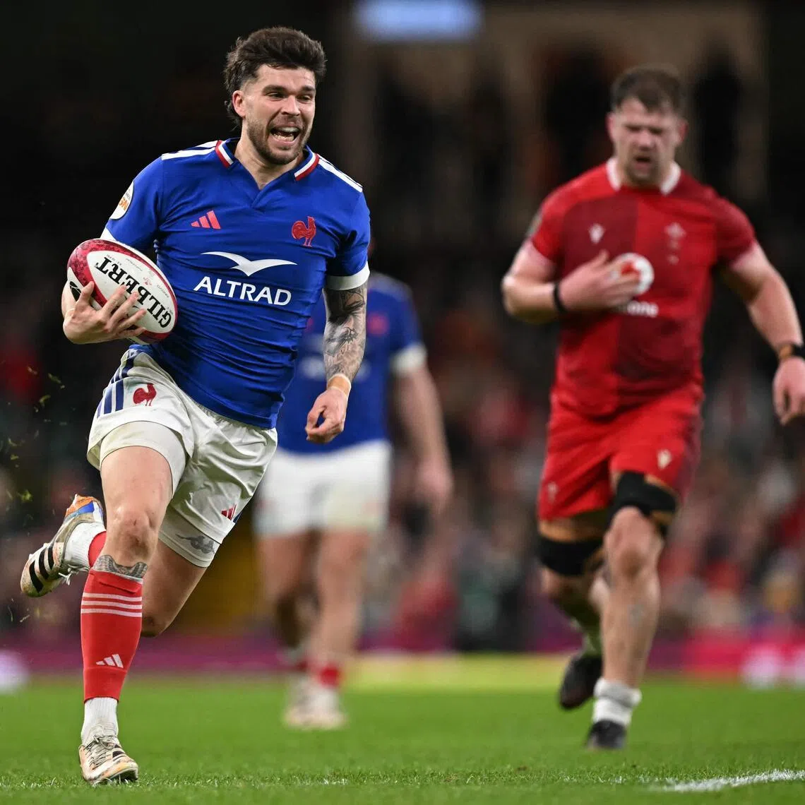 France's fly-half Matthieu Jalibert runs in a try during the Six Nations match against Wales at the Principality Stadium in Cardiff.