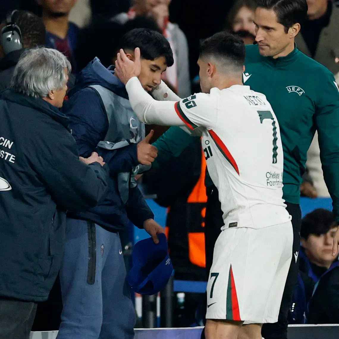 Soccer Football - UEFA Champions League - Round of 16 - First Leg - Paris St Germain v Chelsea - Parc des Princes, Paris, France - March 11, 2026 Chelsea's Pedro Neto checks on ball boy after falling into him Action Images via Reuters/Peter Cziborra