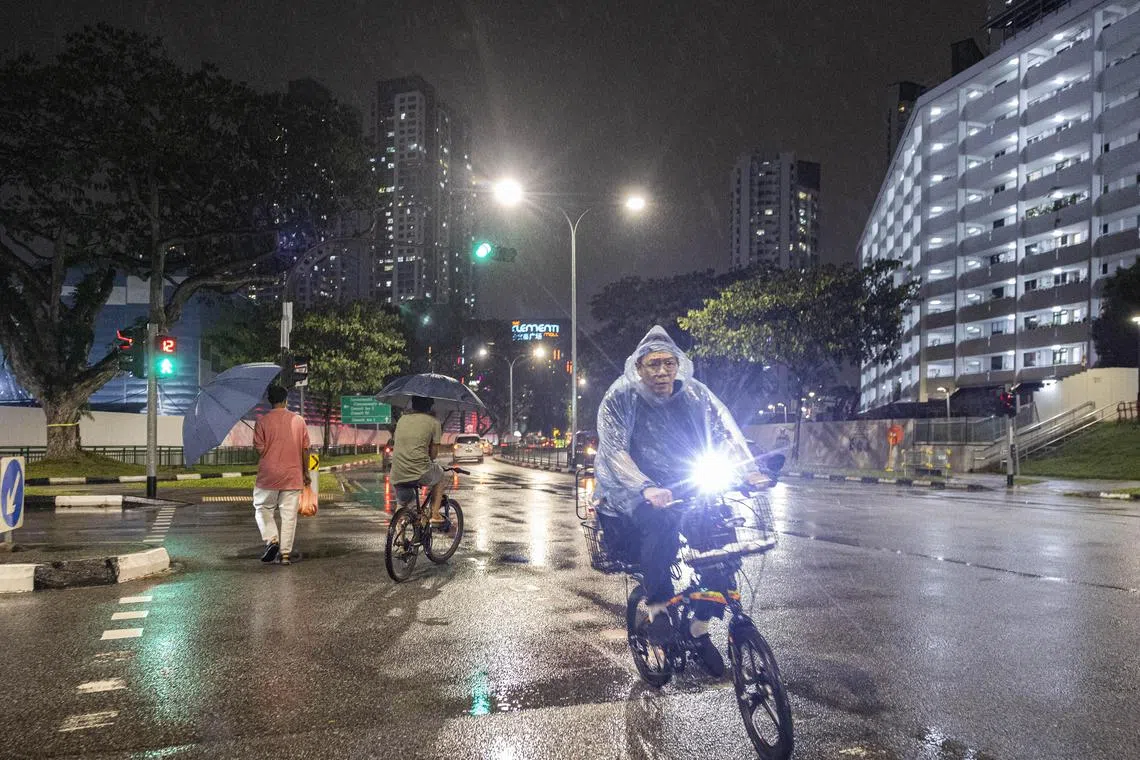 Pedestrians crossing the road in the rain at Clementi on June 17, 2025. 