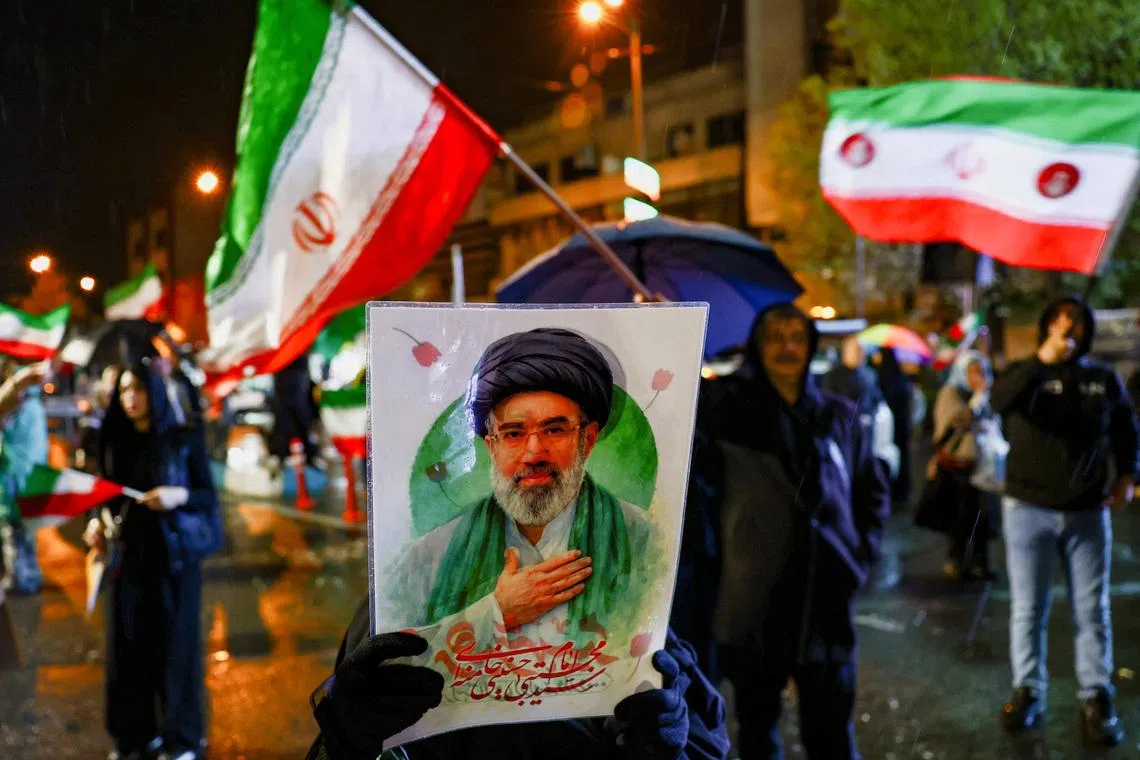 A woman holds a poster depicting Iran’s new Supreme Leader Mojtaba Khamenei during an anti-U.S. and anti-Israeli rally, amid the U.S.-Israeli conflict with Iran, in Tehran, Iran, March 26, 2026. Majid Asgaripour/WANA (West Asia News Agency) via REUTERS