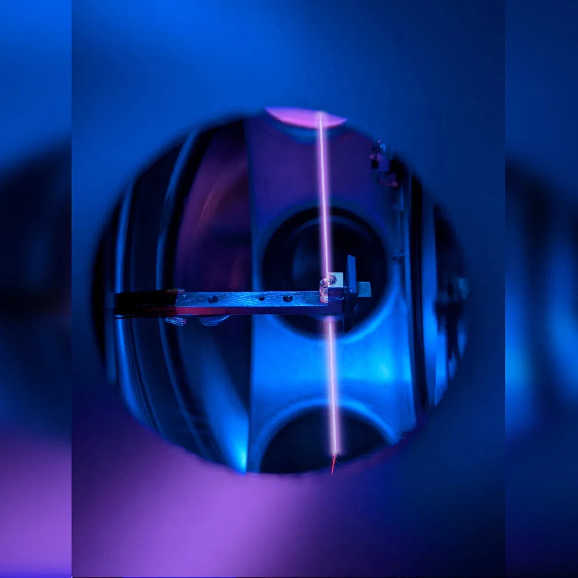 A calcium fluoride crystal is seen in its holder, inside the vacuum system of a nuclear clock at TU Wien, in Vienna, Austria. A laser beam probes thorium nuclei trapped in the crystal.