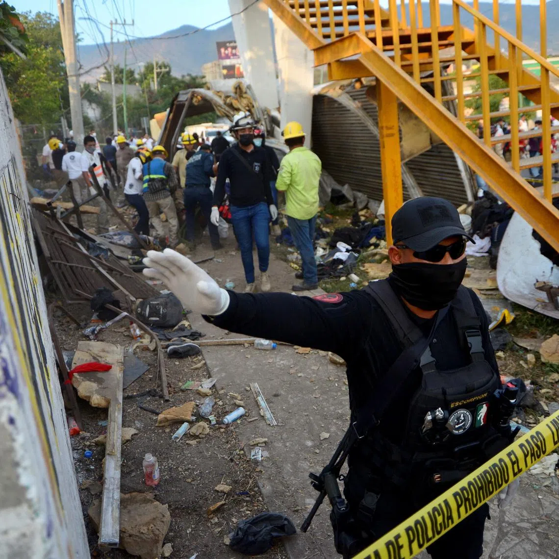A police officer raises his arm to block photographers to to avoid taking pictures at the site of a trailer accident that left at least 49 people dead, most of them migrants from Central America, in Tuxtla Gutierrez, in Chiapas state, Mexico December 9, 2021. REUTERS/Jacob Garcia