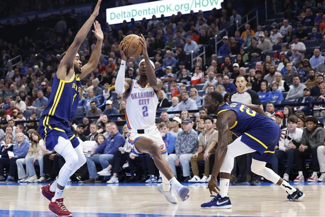 Oklahoma City Thunder guard Shai Gilgeous-Alexander drives to the basket against Golden State Warriors guard Moses Moody and forward Draymond Green during the second quarter at Paycom Centre.