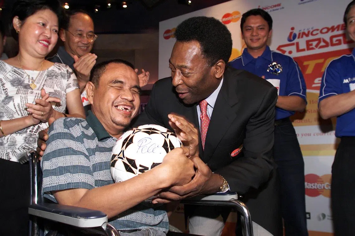 Rasid Mohd Noor, a blind S-League fan, meets
his lifelong idol, Pele, at the annual S-League
fan party at Planet Hollywood on 4 Dec 2001.