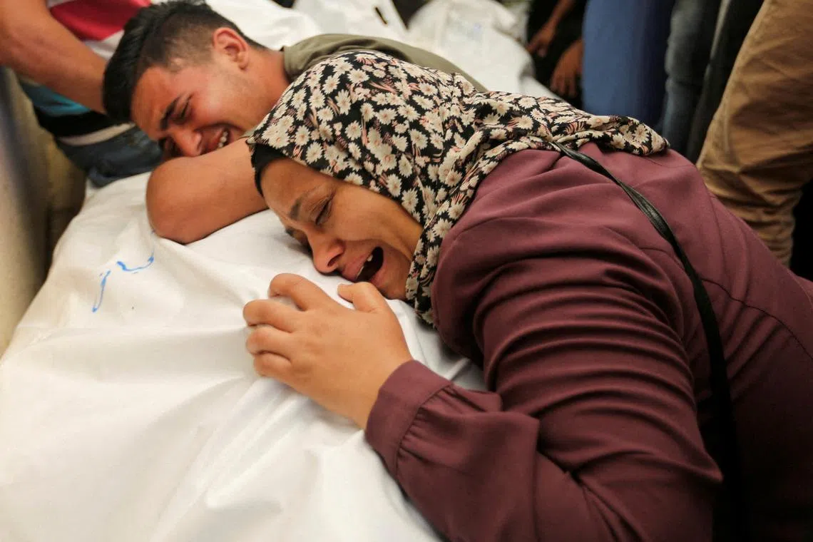 Mourners react next to the bodies of Palestinians, killed in Israeli strikes due to a military operation in Rafah, amid the Israel-Hamas conflict, during their funeral in Khan Younis, in the southern Gaza Strip, June 18, 2024. REUTERS/Hatem Khaled