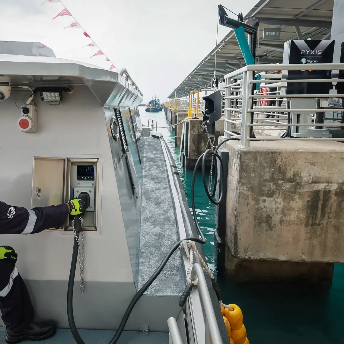 A worker charging the Pyxis X Tron, a fully electric passenger vessel, berthed at Marina South Pier on April 8, 2024.
